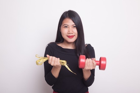 Healthy Asian woman with dumbbells and measuring tape on white backgroundの写真素材