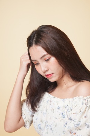 Portrait of beautiful young Asian woman on beige backgroundの写真素材