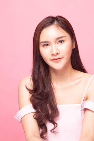 Portrait of beautiful young Asian woman on pink backgroundの写真素材