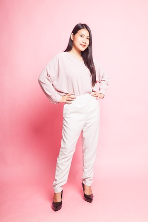 Beautiful young Asian woman in pink shirt on pink backgroundの写真素材