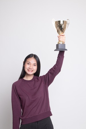 Successful young asian woman holding a trophy on white backgroundの写真素材