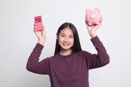 Asian woman with calculator and piggy bank on white backgroundの写真素材