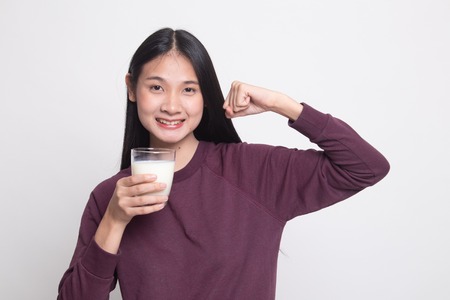Healthy Asian woman drinking a glass of milk on white backgroundの写真素材