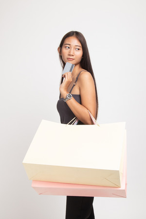 Young Asian woman with shopping bag and blank card on white backgroundの写真素材