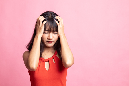 Young Asian woman got sick and  headache on pink backgroundの写真素材