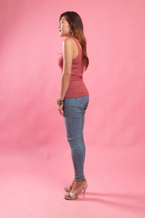 Side Full body of beautiful young asian woman on pink backgroundの写真素材