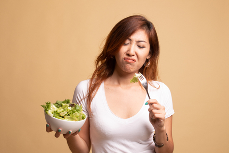 Asian woman hate salad on beige backgroundの写真素材