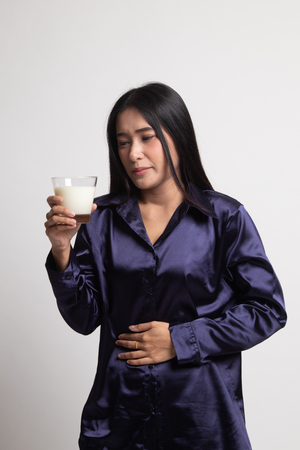 Asian woman drinking a glass of milk got stomachache on white backgroundの写真素材
