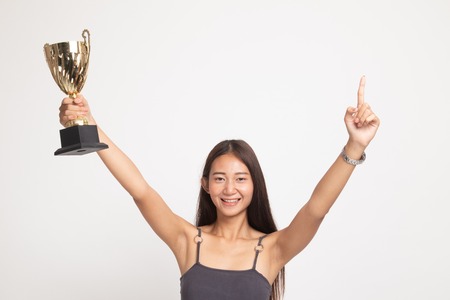 Successful number one winner young asian woman holding a trophy on white backgroundの写真素材