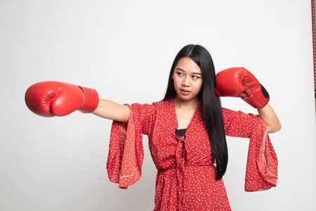 Young Asian woman with red boxing gloves on white background