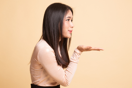 Beautiful young Asian woman blow a kiss on  beige backgroundの写真素材