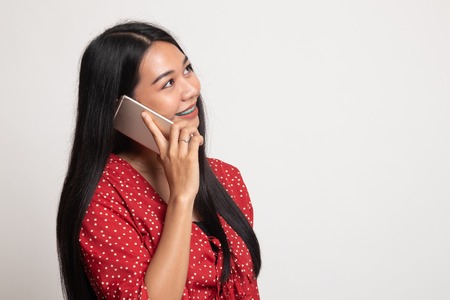 Young Asian woman talking with mobile phone on white backgroundの写真素材