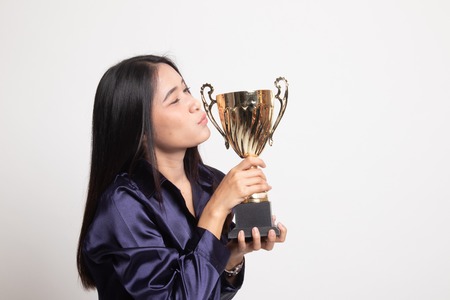 Successful young asian woman holding kissing a trophy on white background
