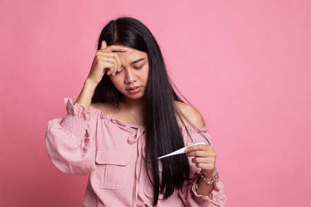 Young Asian woman got sick and flu on pink backgroundの写真素材