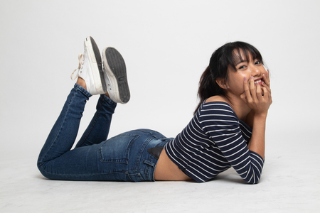 Full body of  beautiful young Asian woman  lay on floor  on white backgroundの写真素材