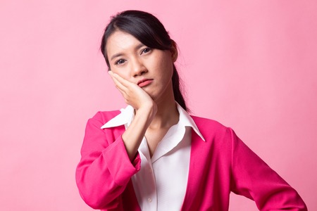 Young Asian woman got toothache on pink backgroundの写真素材