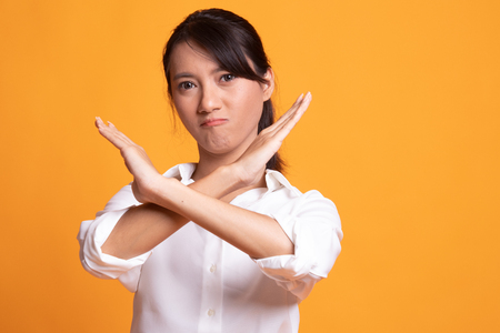 Beautiful young Asian woman say no on yellow backgroundの写真素材