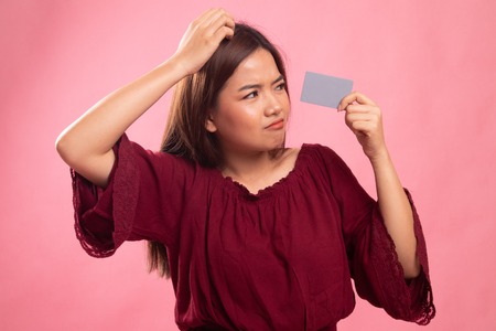 Young Asian woman headache with a blank card on pink background