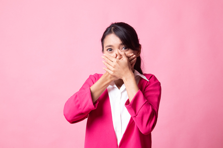 Beautiful young Asian woman close her mouth on pink backgroundの写真素材