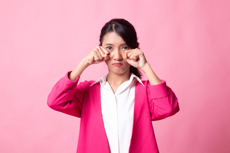 Young Asian woman sad and cry on pink backgroundの写真素材