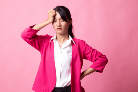 Young Asian woman got sick and  headache on pink backgroundの写真素材