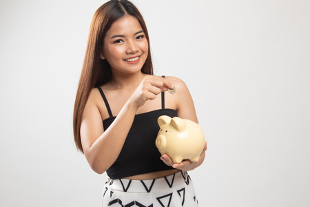Asian woman with coin and pig coin bank on white backgroundの写真素材