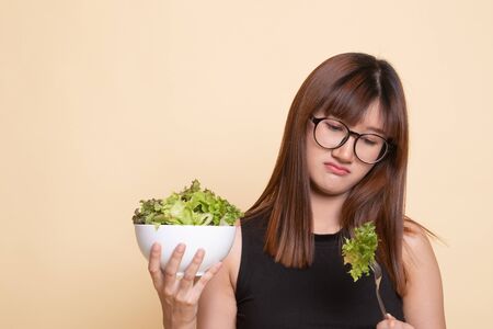 Asian woman hate salad  on beige backgroundの写真素材