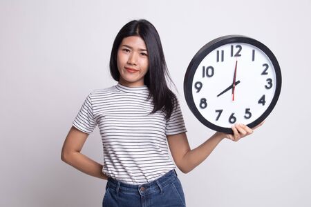 Young Asian woman with a clock on white backgroundの写真素材