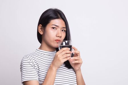 Young Asian woman with a glass of drinking water on white backgroundの写真素材