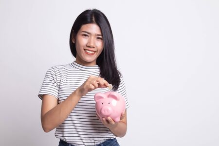 Asian woman with coin and pig coin bank on white backgroundの写真素材