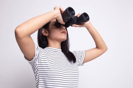 Young Asian woman with binoculars on white backgroundの写真素材