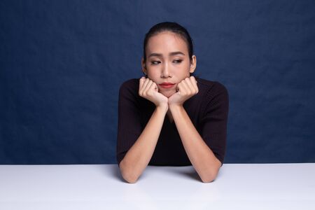 Asian girl with sad emotion on blue backgroundの写真素材
