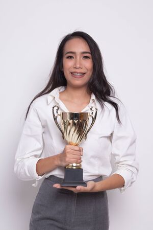 Successful young asian woman holding a trophy on white backgroundの写真素材