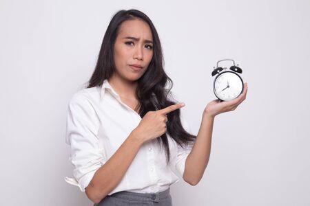 Angry young Asian woman point to a clock on white background