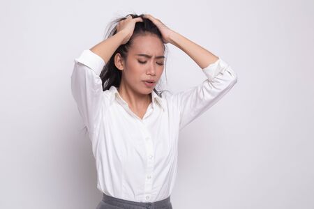 Stressed young Asian businesswoman scream out on white backgroundの写真素材
