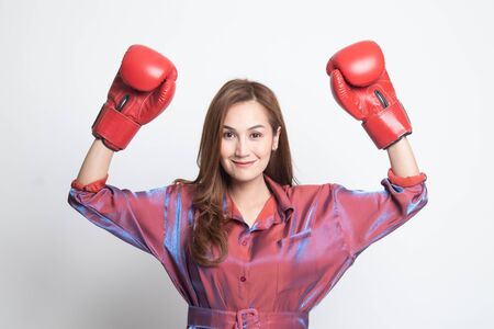 Young Asian woman with red boxing gloves on white background