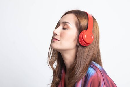 Pretty asian girl listening music with her headphones on white backgroundの写真素材