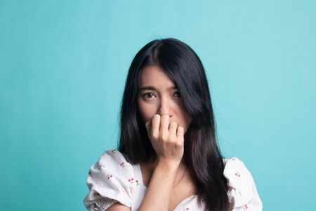 Unsure hesitant nervous young asian  woman biting her fingernails