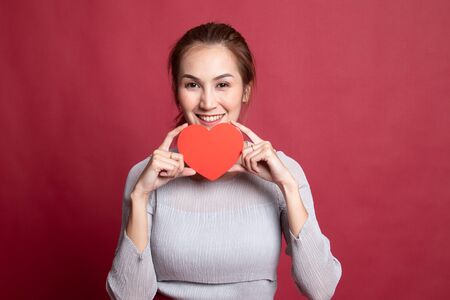 Asian woman with red heart on red background