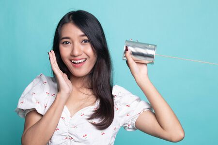 Happy Young Asian woman listen with tin can phoneの写真素材
