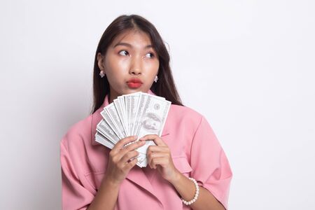 Portrait of  young asian woman  showing bunch of money banknotes on white background.の写真素材