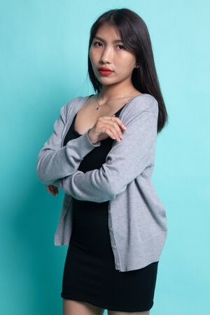 Portrait of beautiful young Asian woman on cyan background.の写真素材
