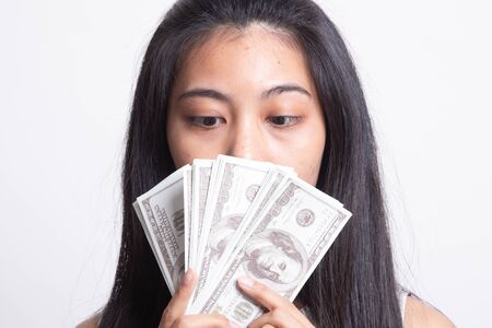 Portrait of  young asian woman  showing bunch of money banknotes on white backgroundの写真素材
