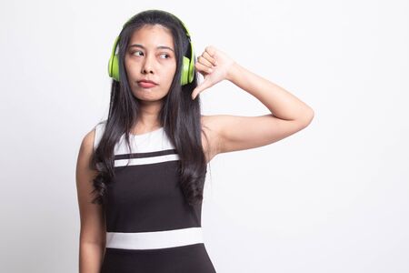 Asian girl don't like  music show thumb down with her headphones on white backgroundの写真素材