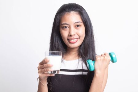 Healthy Asian woman drinking a glass of milk and dumbbell on white backgroundの写真素材