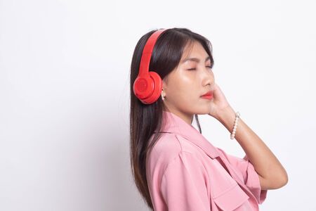 Pretty asian girl listening music with her headphones on white background.の写真素材