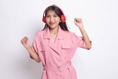Pretty asian girl listening music with her headphones on white background.の写真素材