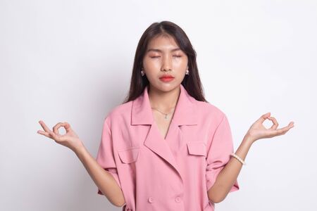 Concentrated relaxed  asian  female  closed eyes, having relaxation while meditating, trying to find balance and harmony Yoga and meditation concept on white background.の写真素材