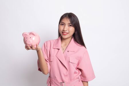 Young Asian woman with a pig coin bank on white background.の写真素材