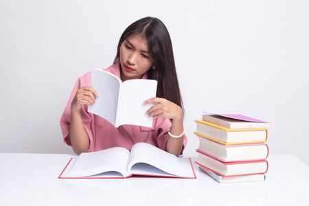 Young Asian woman read a book with books on table on white background.の写真素材